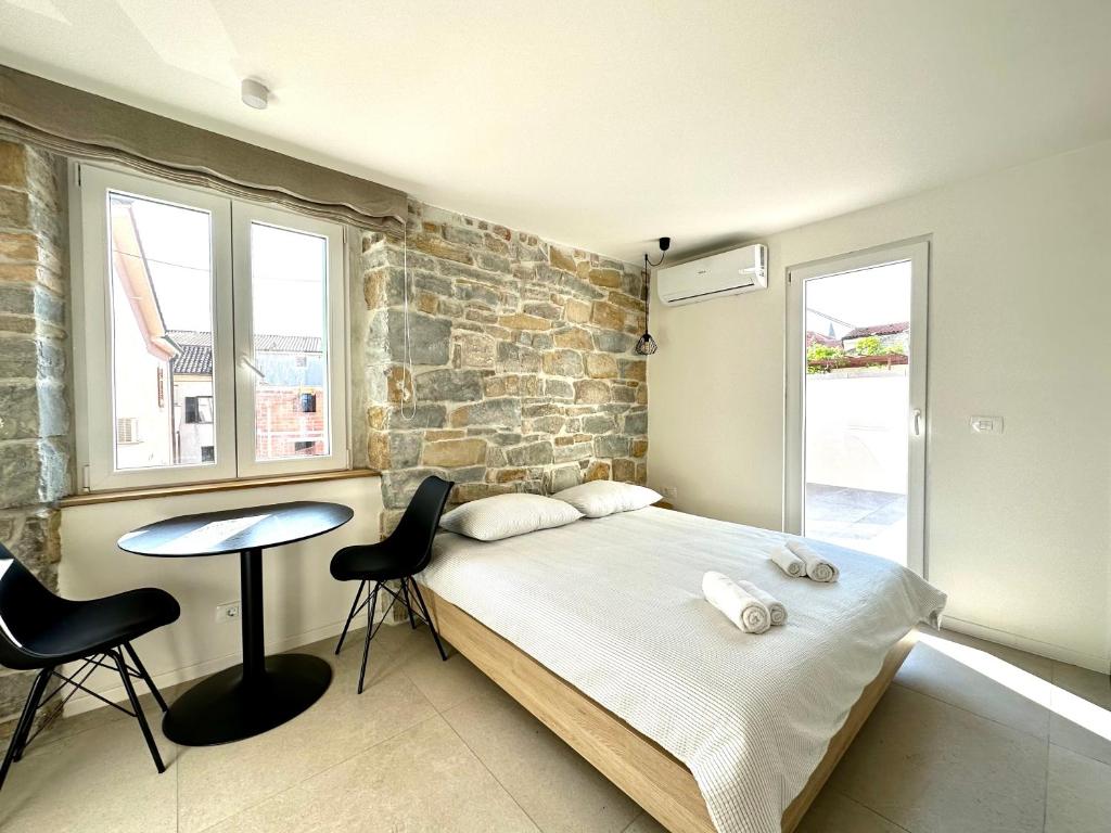 ein Schlafzimmer mit einem Bett und einer Ziegelwand in der Unterkunft Damir Skomina Apartments in Koper