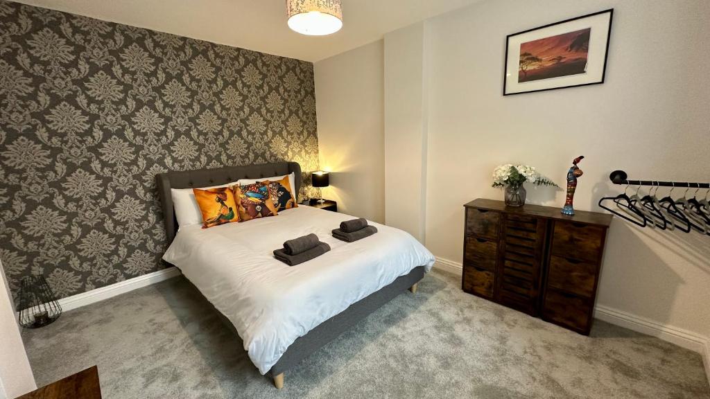 a bedroom with a bed and a wooden dresser at Stylish & Cosy - Flat 6, Osborne Road in Pontypool