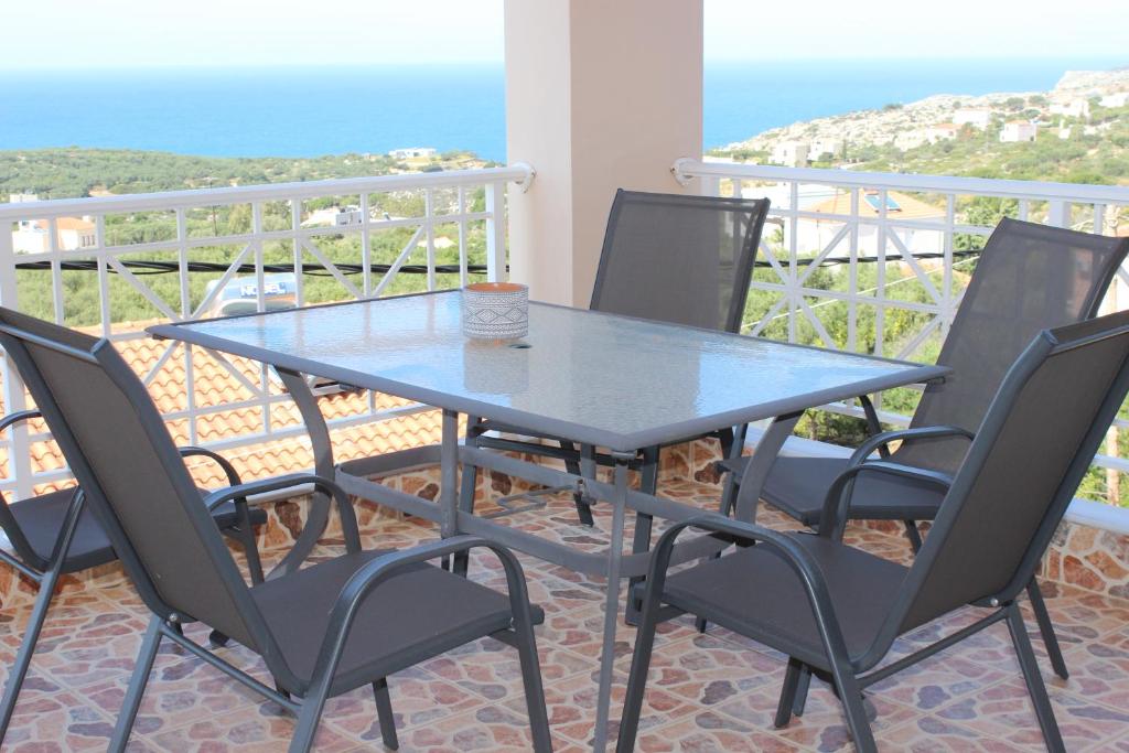 a table and chairs on a balcony with the ocean at TOTEM Sea View Apartment in Plaka