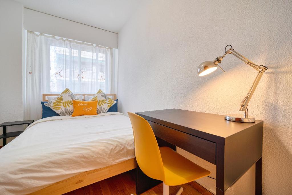1 dormitorio con escritorio y 1 cama con silla amarilla en CasaCafé Madrid Pozuelo 2 Baño Fuera de la habitacion o COMPARTIDO en Pozuelo de Alarcón