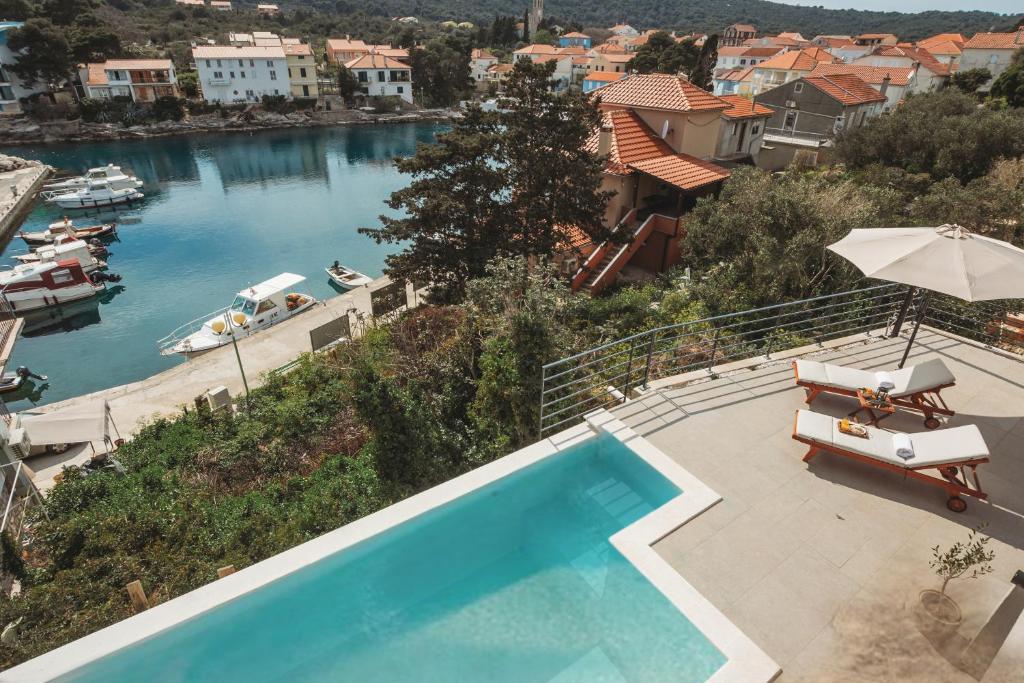 een zwembad met uitzicht op een rivier bij SOL luxury residence near the beach with shared heated pool in Božava