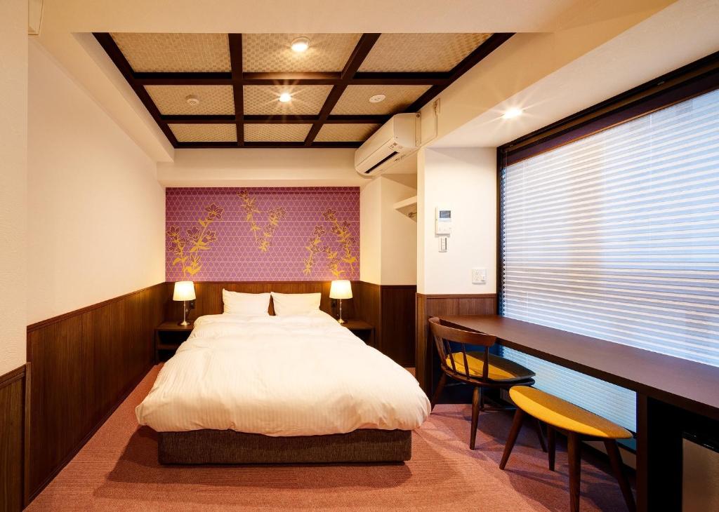 a bedroom with a bed and a desk and a window at Hotel Sanriiott Kitahama - Vacation STAY 33596v in Osaka