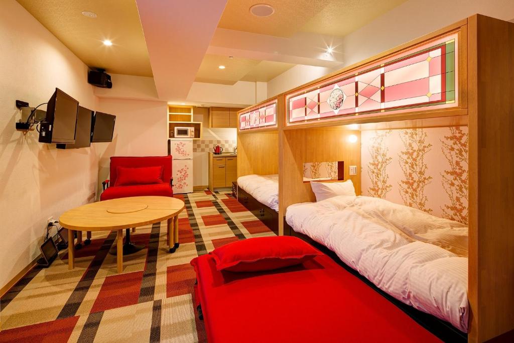 a small room with two beds and a table at Hotel Sanriiott Kitahama - Vacation STAY 33472v in Osaka