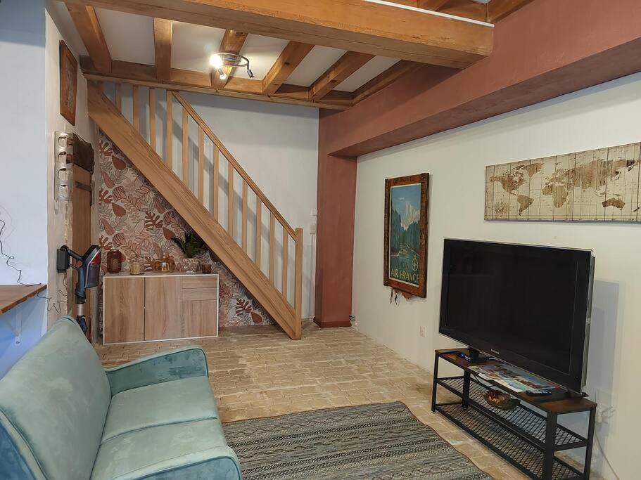 un salon avec un canapé et une télévision à écran plat dans l'établissement Moulin de Pisseloube, à Montchaude