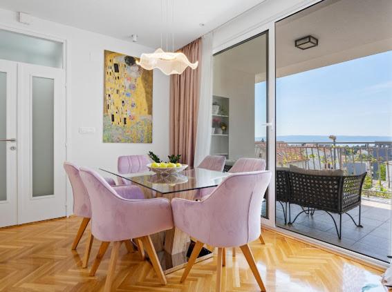 comedor con mesa y sillas rosas en Luxury Apartment Beyond, en Stobreč