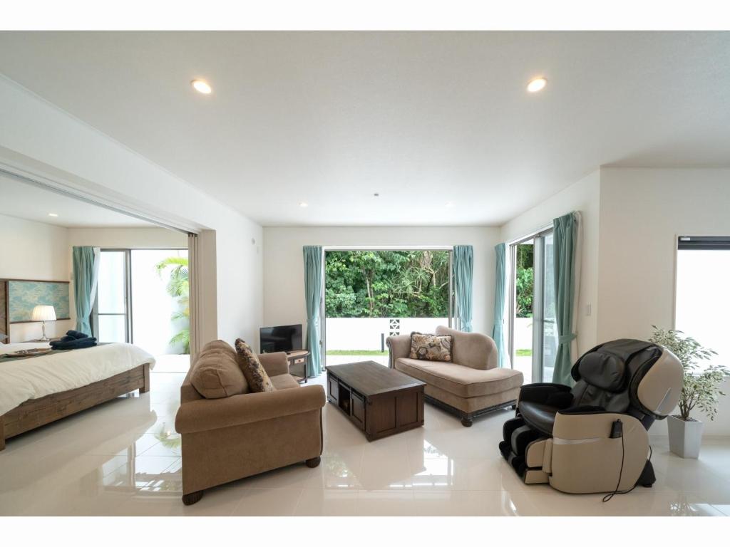 a living room with a bed and a couch and chairs at kukulu island - Vacation STAY 37864v in Kouri