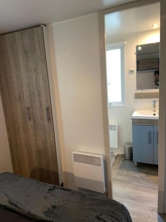 a bedroom with a door and a kitchen with a sink at Mobilhome 516 in La Teste-de-Buch