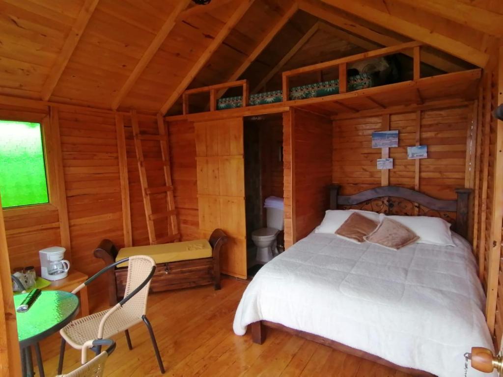 um quarto com uma cama num chalé de madeira em Cabañas Guatavita em Guatavita