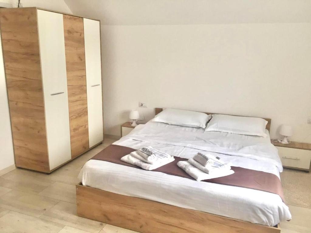 a bedroom with a large bed with two towels on it at Pensiunea Axenia Ale in Vişeu de Sus