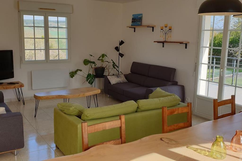 a living room with a couch and a table at Le Bellevue à 1 h 30 de Paris et 20 km de Troyes in Estissac