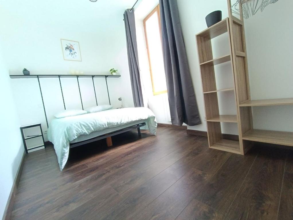 a bedroom with a bed and a wooden floor at Escapade blésoise in Blois