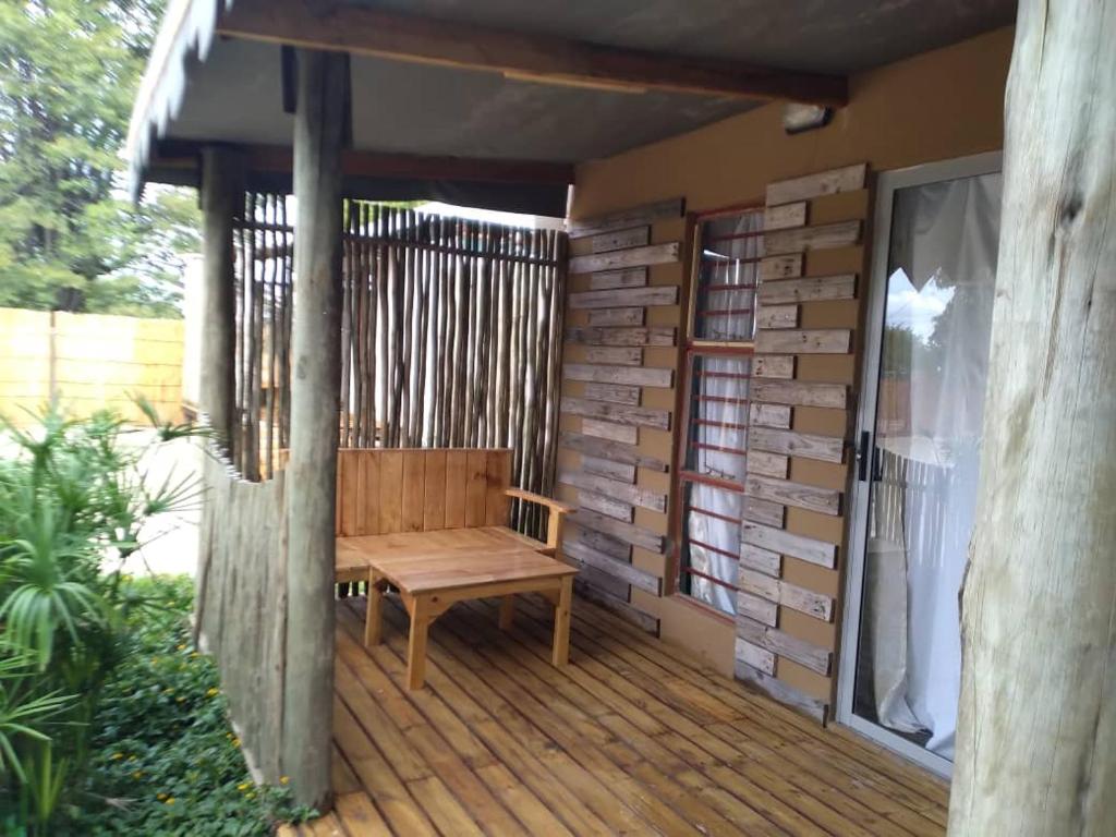 a wooden bench sitting on a wooden deck at Kadavu Accommodations in Maun