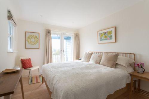 um quarto com uma cama, uma secretária e uma janela em Bowden Wood em Dartmouth