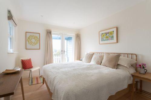 a bedroom with a bed and a desk and a window at Bowden Wood in Dartmouth