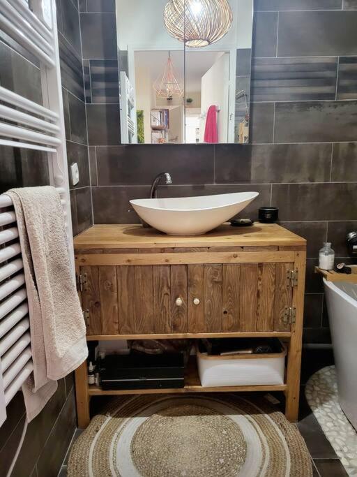 a bathroom with a bowl sink on a wooden vanity at Une invitation à la détente in Nice