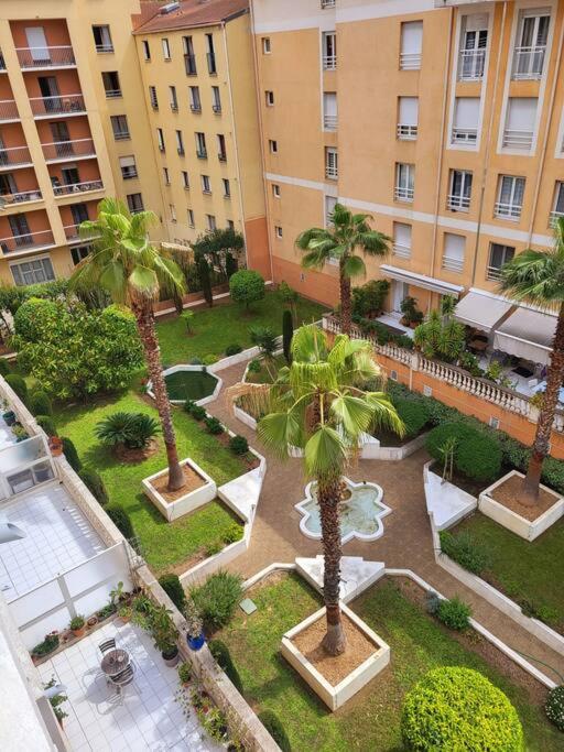 an aerial view of a courtyard with palm trees and buildings at Une invitation à la détente in Nice