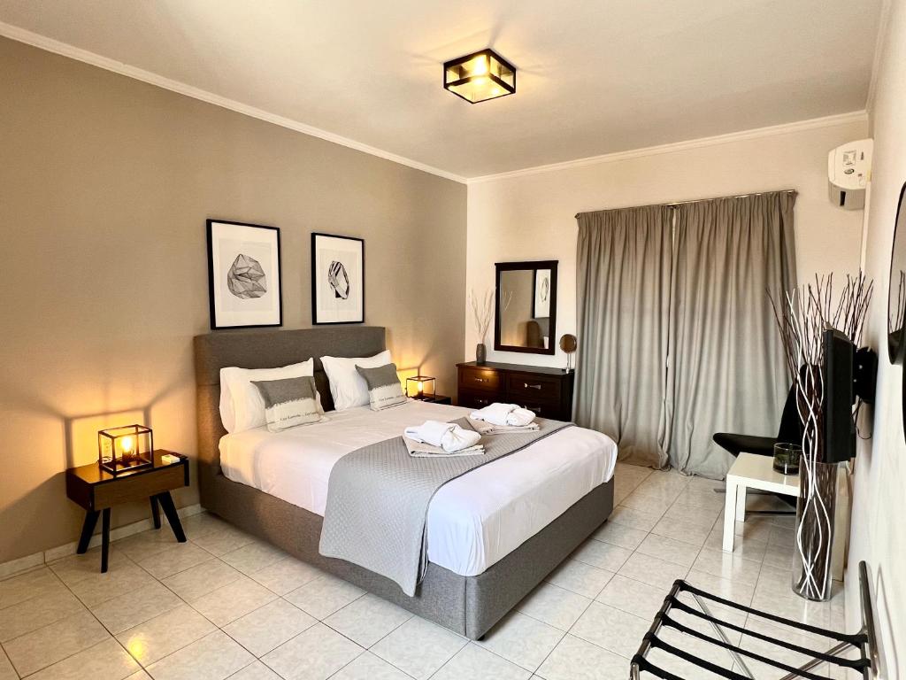 una habitación de hotel con una cama grande y una silla en Ven Luxury Apartment en Zakynthos
