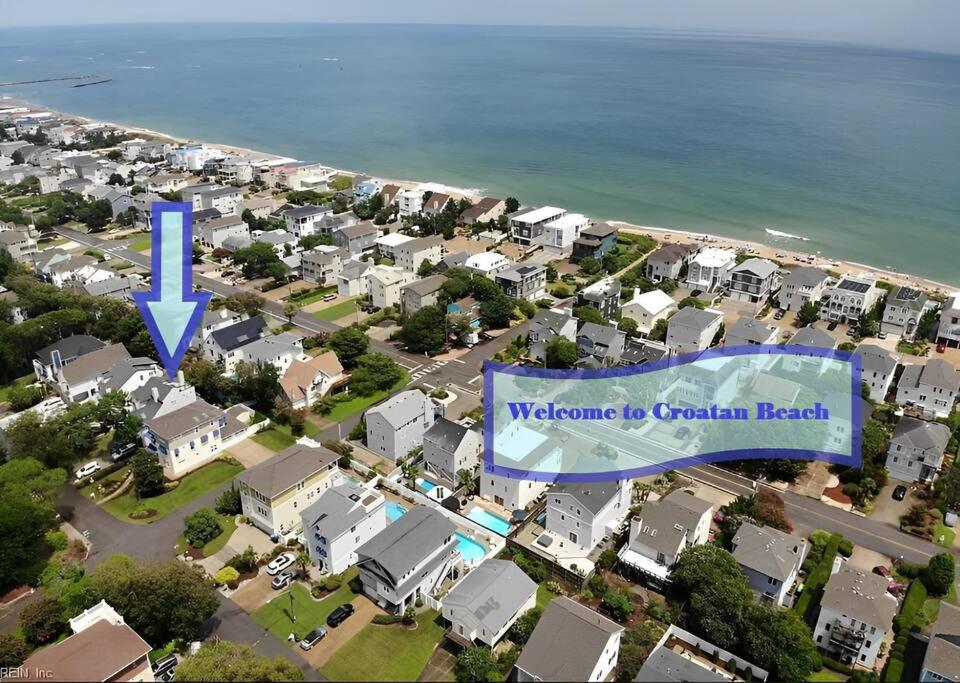 Vista árida de un suburbio residencial con una señal azul en Croatan Beach House - Big Kitchen, Hot Tub, 2 Masters en Virginia Beach