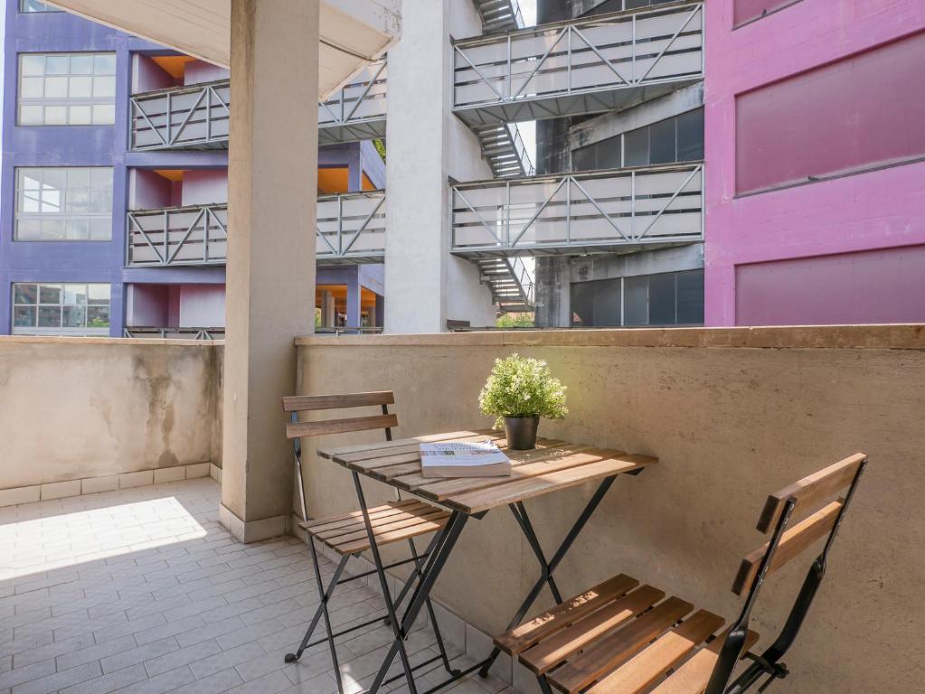 a table and chairs on a balcony with a building at I Host Apartment - San Faustino 78 in Milan