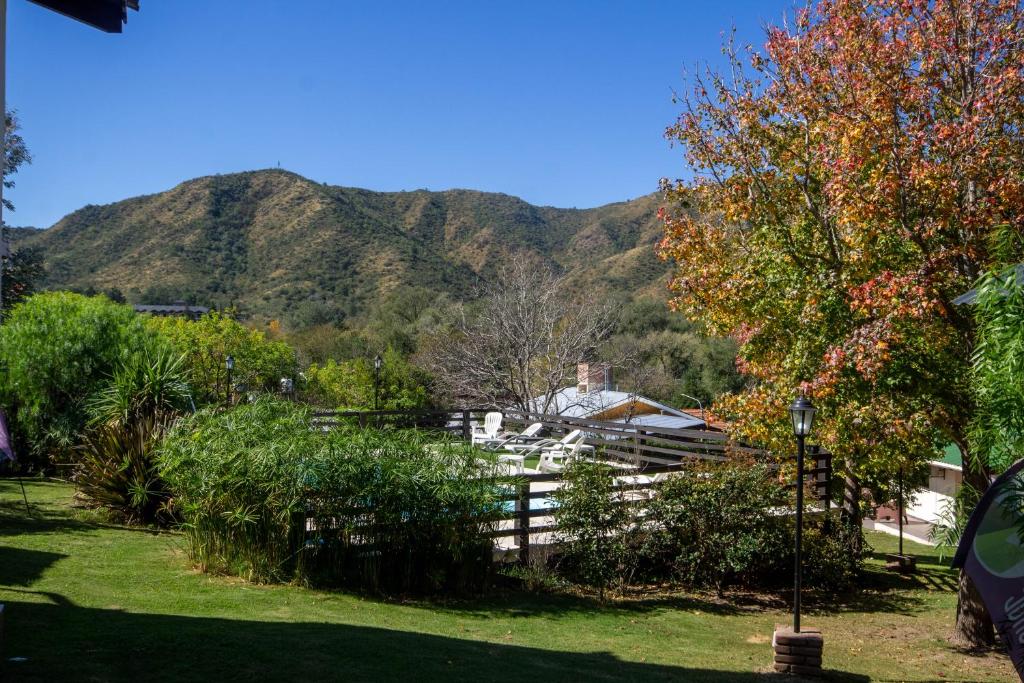 uma cerca com uma montanha ao fundo em Cabañas Noscohue em Villa General Belgrano