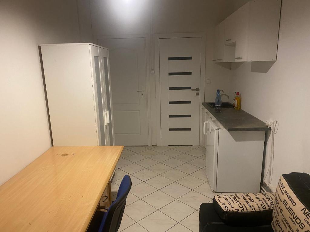 a kitchen with a table and a refrigerator and a counter at Fałata apartament in Kobyłka