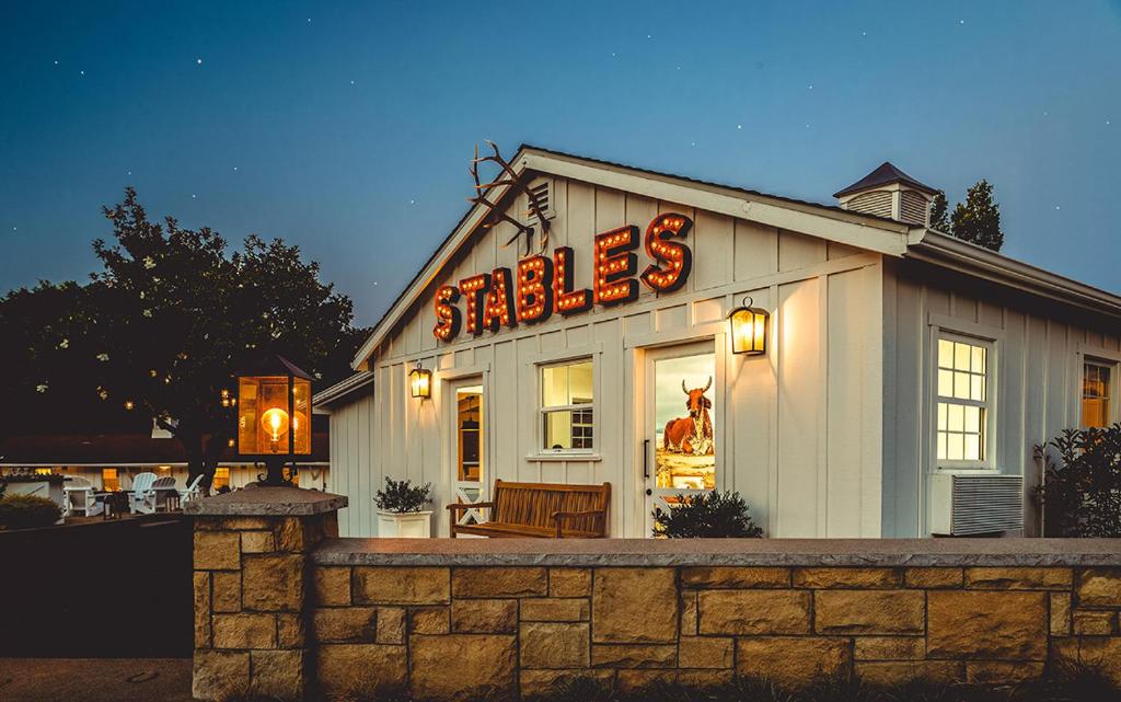 a building with a sign that reads smiles at Stables Inn in Paso Robles