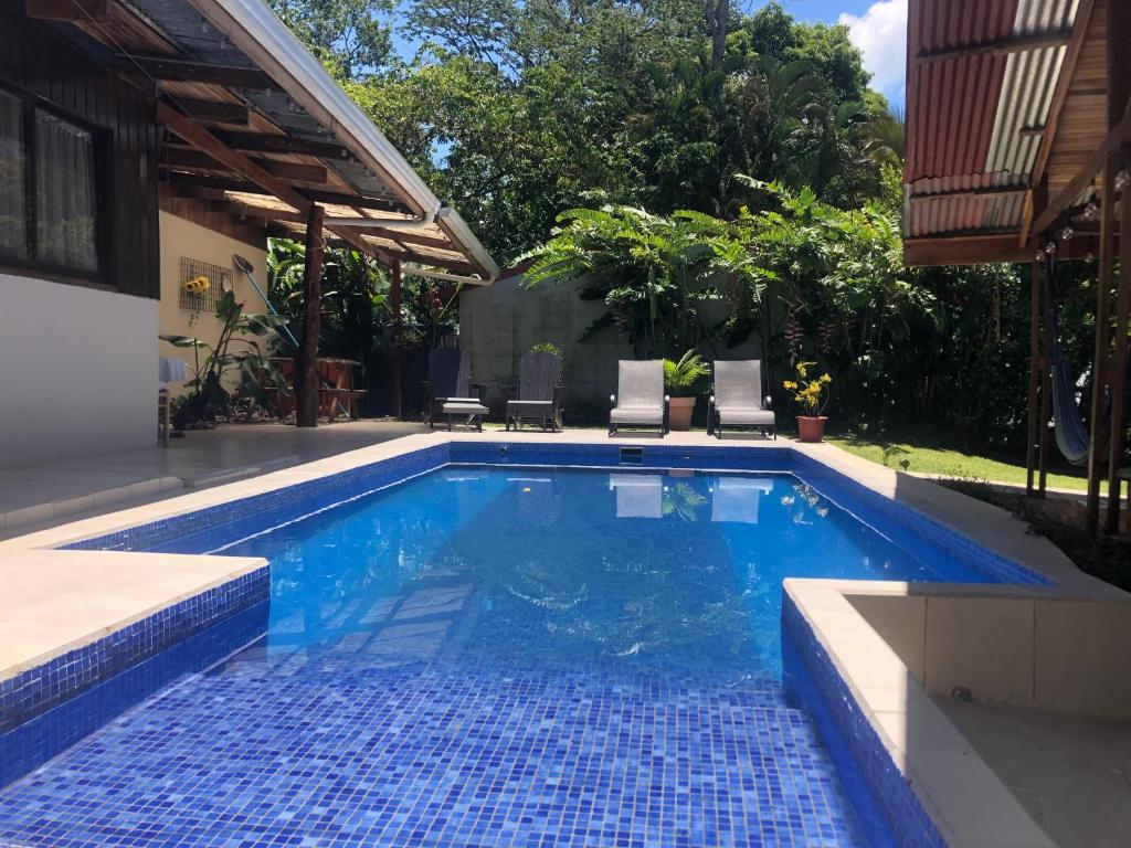 a swimming pool with blue tiles in a backyard at Le Petit Hotel in Fortuna