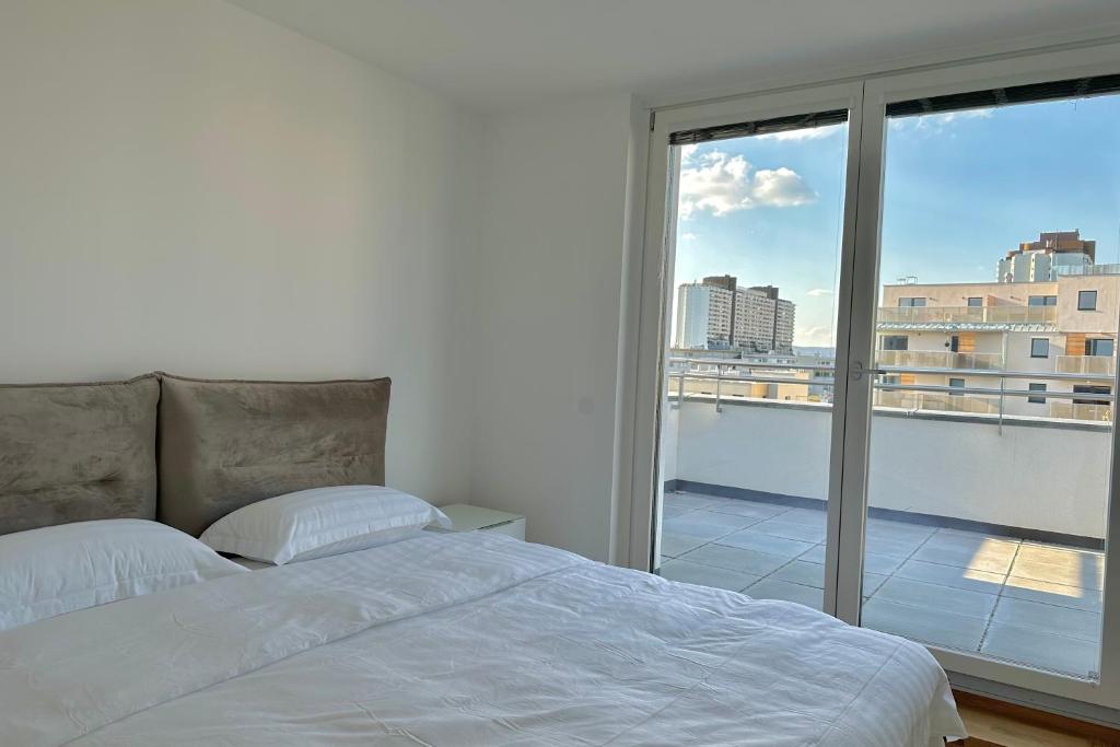 a bedroom with a bed and a large window at Penthouse in Vienna - near metro in Vienna