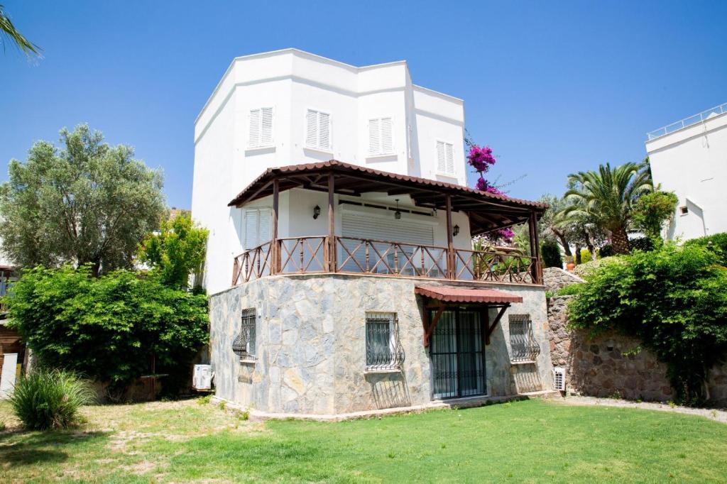 an old stone house with a balcony on a lawn at Luxury Villa in Türkbükü Bodrum Turkey close to Maca Kızı in Bodrum City
