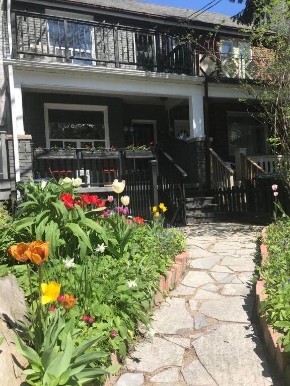un jardín frente a una casa con flores en Beautiful house in central Toronto with backyard en Toronto
