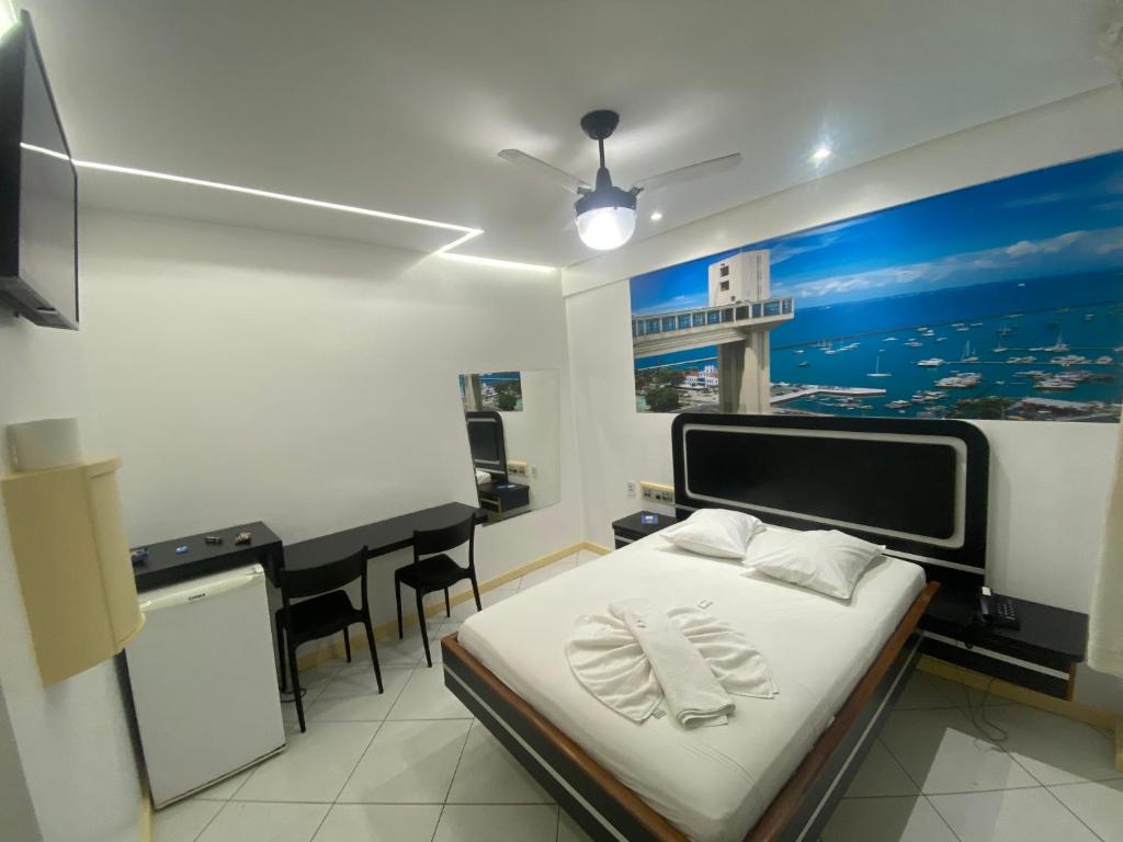 een slaapkamer met een bed en een bureau met een bureau bij Hotel Novo Plano in Salvador