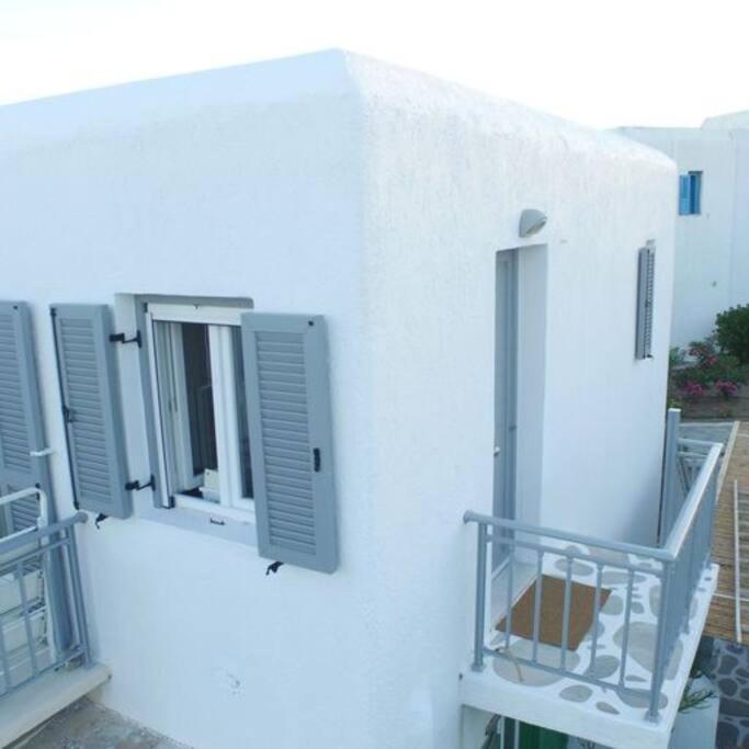 a white building with three windows and a balcony at Costa Ilios 3 Bedroom Flat in Ornos