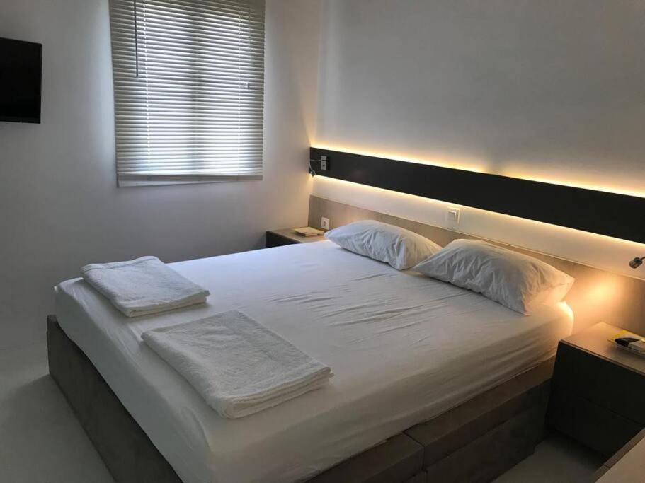 una camera da letto con un grande letto bianco con luci sopra di Costa Ilios 3 Bedroom Flat a Ornos