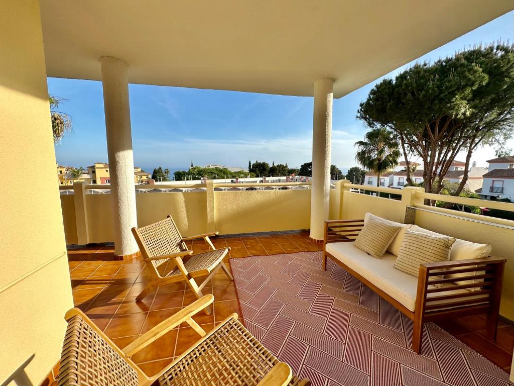 d'une terrasse avec un canapé et des chaises sur un balcon. dans l'établissement Seaview and big terrace Cabopino, à Marbella