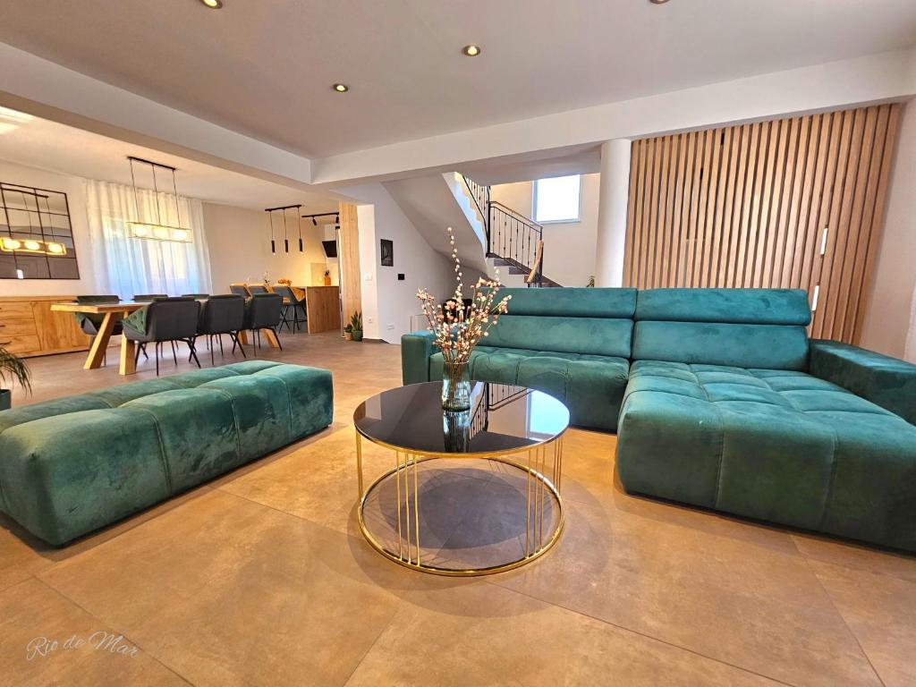 a living room with a green couch and a table at Apartman Rio de Mar in Bibinje