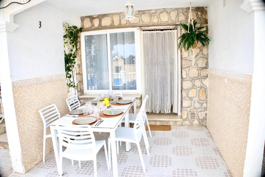 a white dining room with a white table and chairs at MARINA VILLAGE Peñíscola in Peñíscola
