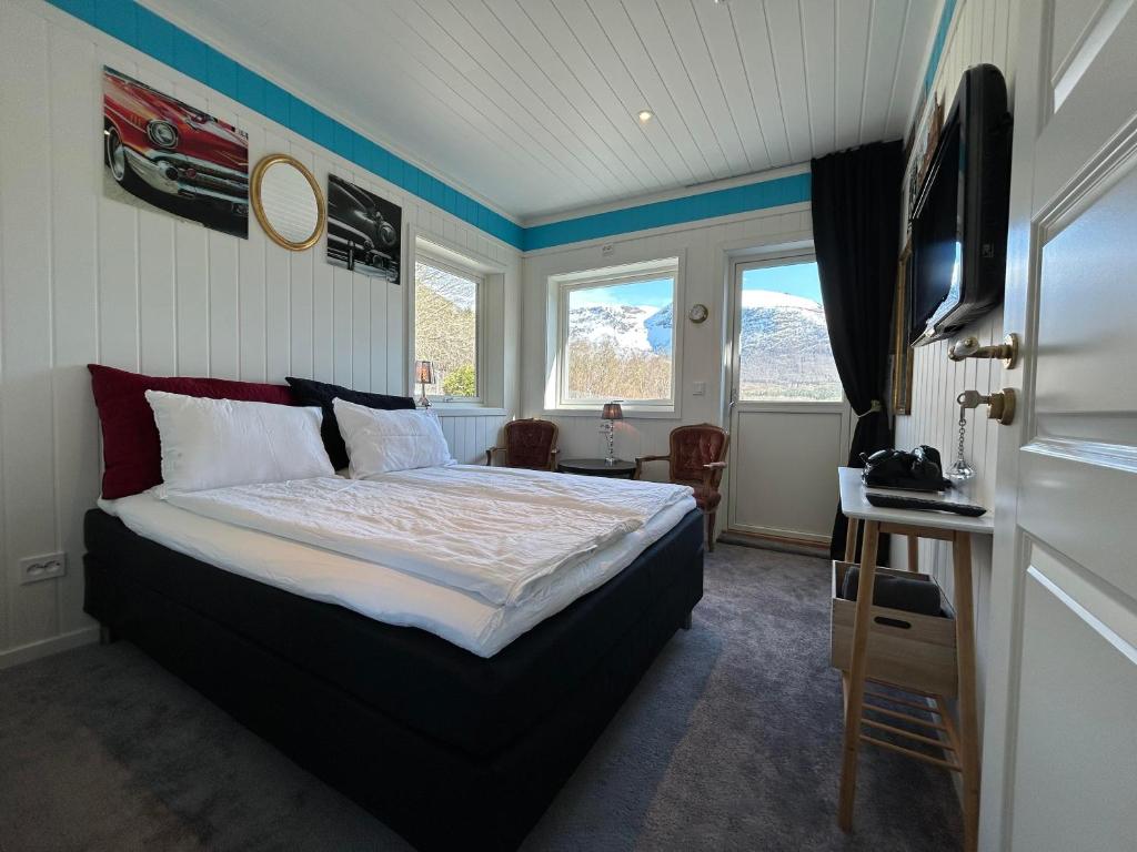 um quarto com uma cama, uma secretária e janelas em Rødseth gårdsovernatting Dobbeltrom em Molde