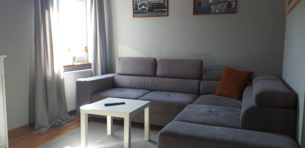 sala de estar con sofá y mesa en Cichy zakątek, en Naniec