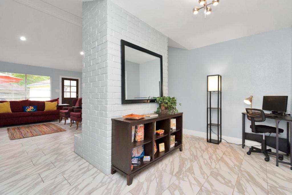a living room with a mirror on a white brick wall at Everything under 5 min. The Woodlands TX. Fully Equipped for Long stays as well. in Shenandoah