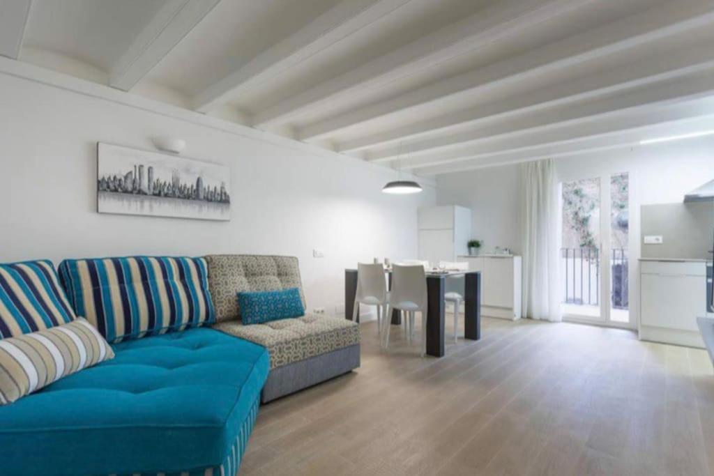 sala de estar con sofá azul y mesa en Beautiful and best location apt en Barcelona