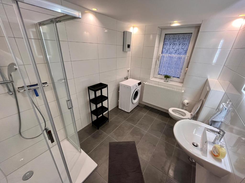 a bathroom with a shower and a sink and a toilet at Monteurunterkunft Simmershausen - Parken, Waschen und Wifi inklusive in Fuldatal