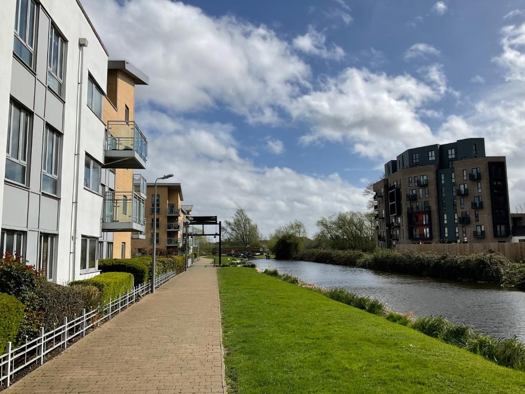 a walkway next to a river next to buildings at Beautiful Riverview Apartment Chelmsford in Chelmsford