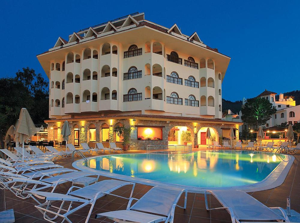 um hotel com piscina em frente a um edifício em Fortuna Beach Hotel em Marmaris