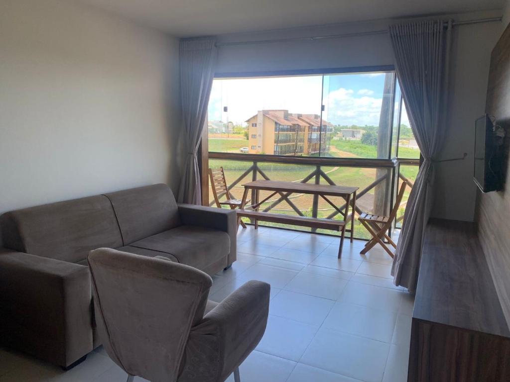 a living room with a couch and a balcony at Cond. Sonhos da Serra in Bananeiras