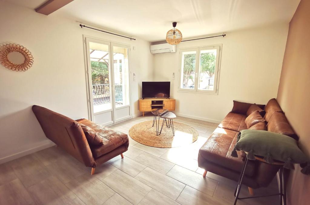 a living room with a couch and a tv at KiWi in Canet-en-Roussillon