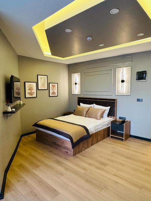 a bedroom with a large bed with a ceiling at Skymoon Istanbul Airport Hotel in Arnavutköy