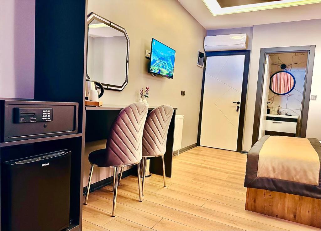 a room with a bed and a desk and two chairs at Skymoon Istanbul Airport Hotel in Arnavutköy