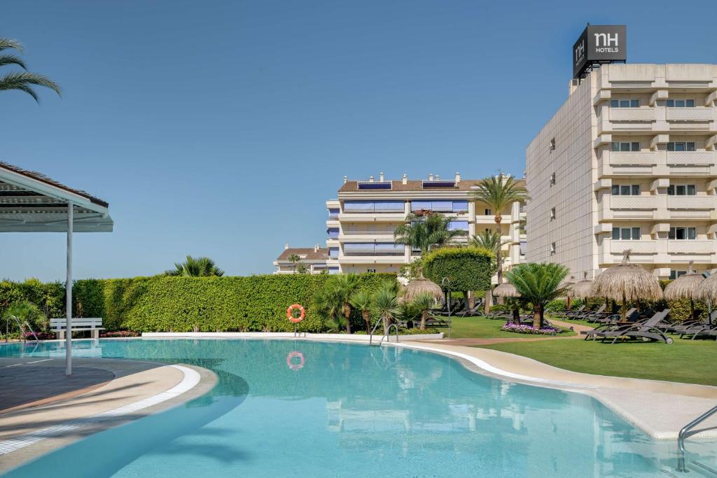 a large swimming pool in front of a building at NH Marbella in Marbella