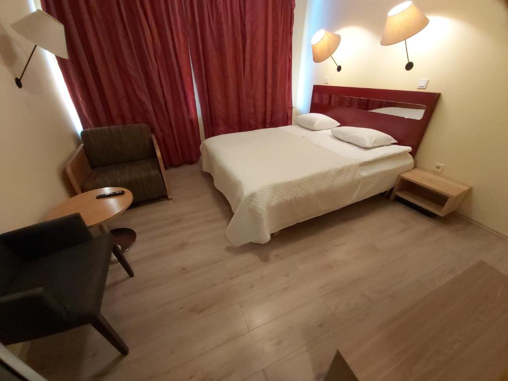 Pokój hotelowy z łóżkiem i krzesłem w obiekcie Viva Nord Hotell w Tallinnie
