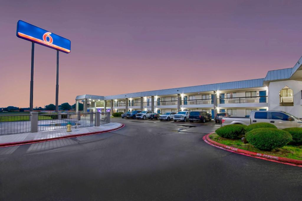 a hotel with cars parked in a parking lot at Motel 6 Texarkana, TX in Texarkana